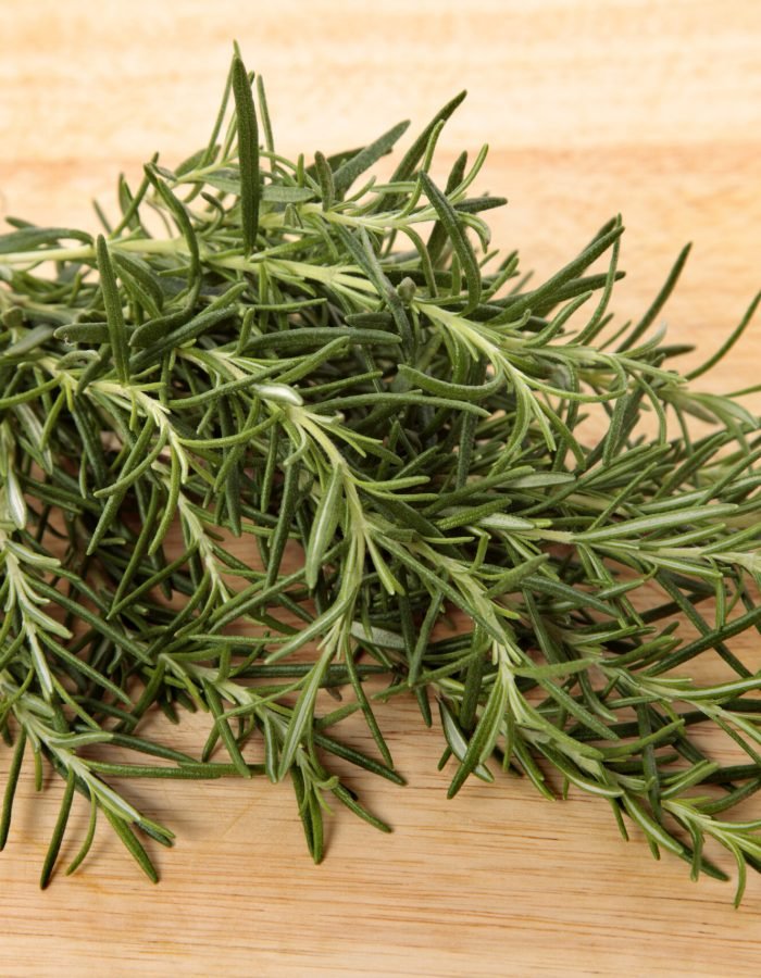 Bunch of fresh rosemary on an old wooden chopping board