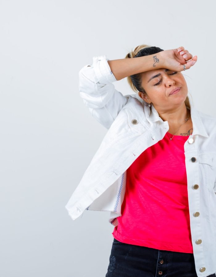 young lady holding arm on forehead in t-Descubra os alimentos que causam cansaço e roubam sua disposição no dia a dia. Saiba como substituí-los e recuperar sua energia com escolhas simples!