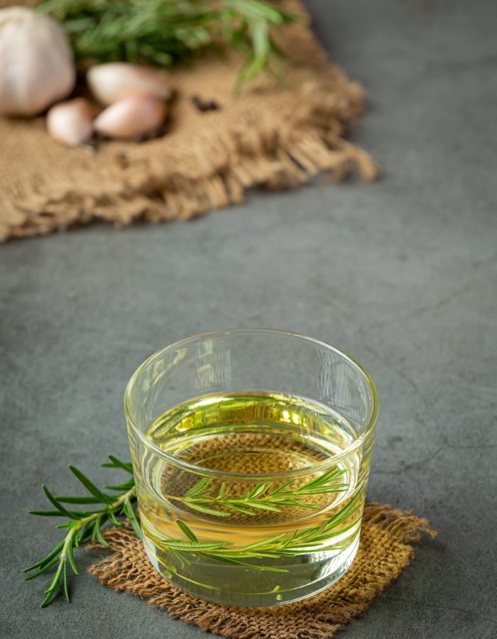 Oil with rosemary on table